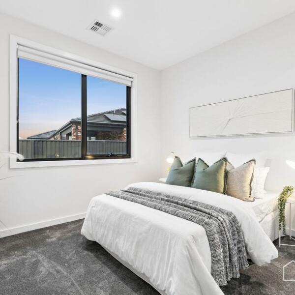 Modern guest bedroom with soft neutral styling and natural light in a new home build Lara