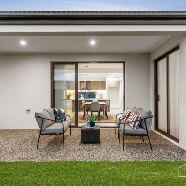 Covered outdoor entertaining area with seamless indoor-outdoor connection in a custom new home Lara