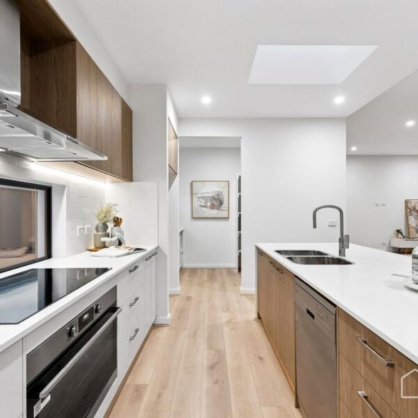 Modern kitchen featuring quality appliances, stone benchtops and spacious island in a custom new home Geelong